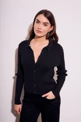 Cardigan negro de punto con cuello polo, manga larga y cierre frontal con botones.