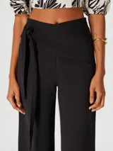 Pantalón negro de corte cropped con lazo en la cintura.