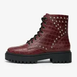 Bota de cuero negra con caña media, cordones y plataforma track. Presenta apliques de tachas plateadas en el lateral exterior.