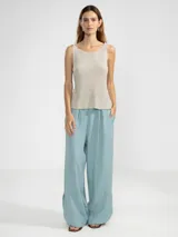 Musculosa color beige con hilo de lúrex, escote redondo y corte ajustado.