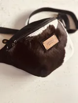 Riñonera de cuero color borgoña con correa ajustable.