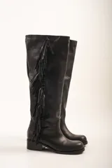 Bota alta de cuero negro con taco bajo y detalle de flecos en el lateral exterior.