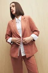 Blazer color beige de corte clásico en tela jaspeada, suave al tacto, liviana y con caída relajada.