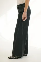 Pantalón de jean acampanado color caramelo con cintura alta y cinturón marrón con tachas.