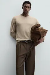 Jersey de hombre color beige claro, tejido en lana, de corte recto, cuello redondo y mangas largas con terminaciones en rib.