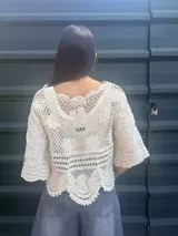 Camisa negra con detalles de crochet color crema, escote en V y mangas 3/4.