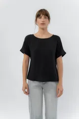 Remera blanca de viscosa liviana, con escote redondo y mangas cortas con vuelta.