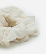 Scrunchie de tela laise color crema con diseño calado.