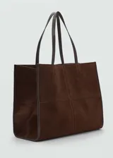Bolso tipo shopper color bordó, confeccionado en cuero vacuno, con cierre de botón magnético, asa de hombro y bolsillo interior.