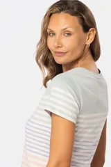 Remera de manga corta con cuello redondo y botones personalizados. Diseño a rayas horizontales en azul, blanco y rosa.