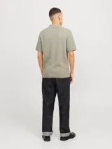 Polo de punto estructurado color beige, de corte regular, con cuello clásico, mangas cortas y cierre con botones.