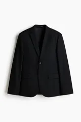 Blazer negro de tejido suave con solapas de muesca finas y ojal decorativo. Modelo de botonadura sencilla con un botón visible, bolsillo superior insertado, dos bolsillos delanteros con solapa y tres bolsillos interiores. Posee botones decorativos en los puños y abertura doble en la espalda. Corte ajustado.