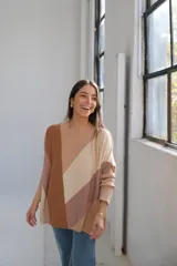 Sweater de punto con cuello redondo y corte murciélago. Diseño con bloques de color diagonales en tonos beige, marrón y tostado.