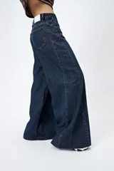 Pantalón jean de calce ultra wide con pierna extra ancha y ruedo desflecado, de tiro medio y construcción clásica en denim.