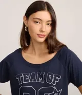 Remera de algodón azul marino con cuello redondo y manga corta. Presenta un estampado frontal en blanco con el texto "TEAM OF" y el número "92" en tipografía deportiva, rodeado de estrellas.