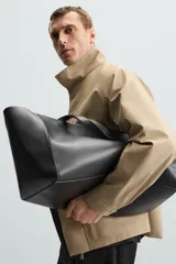 Parka ligera color beige, de corte relaxed fit, confeccionada en tejido técnico repelente al agua. Tiene cuello alto, mangas largas con puños ajustables con botón a presión, bolsillos de solapa en la cadera y cierre frontal con cremallera oculta por solapa con botones a presión.