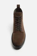 Bota de caña baja color marrón chocolate, de cuero gamuzado, con cordones al tono y suela track color negro.