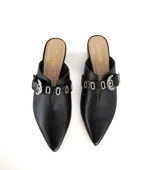 Mulas negras de cuero texturizado con punta afilada, abertura central, tira con hebilla plateada y mini taco metalizado plateado.