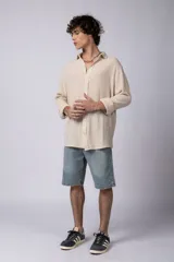 Camisa blanca de lino con cuello clásico, manga larga con puños abotonados y corte holgado. 