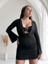Vestido negro de tres piezas, compuesto por un top tipo corpiño con aro dorado, una falda mini fruncida y un cardigan de mangas largas.
