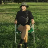 Sombrero negro tipo pescador, confeccionado en poliéster reciclado. Tiene ala mediana, ajuste elástico en la corona y tira ajustable con tanca.