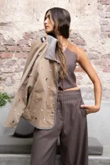 Cazadora color beige con apliques de pedrería y detalles en color marrón.