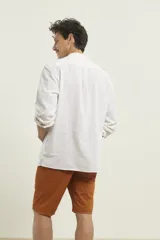 Camisa amarilla de lino con cuello mao y manga larga.