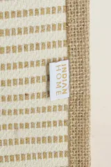 Bolso tipo tote de yute con rayas horizontales color beige y manijas de soga blanca.