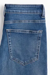 Pantalón de jean de tiro alto con denim levemente elástico, cierre con botón y piernas amplias con bajos acampanados. Cuenta con bolsillos decorativos adelante y bolsillos atrás.