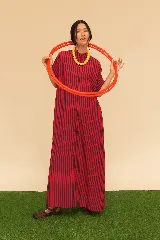 Camisola larga de seda liviana con estampado a rayas verticales en tonos rojo y negro. Tiene corte recto, manga corta y botones frontales.