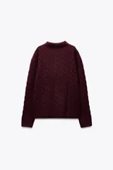 Sweater color borgoña de punto trenzado con cuello polo, manga larga y botones dorados.