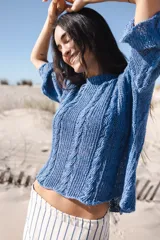 Buzo marrón de lino tejido a mano con cables, de silueta oversize, mangas rectas y cuello a la base.