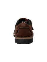 Sandalia de cuero marrón con aberturas y ajuste con velcro.