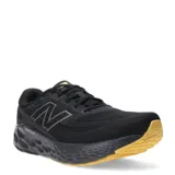 Championes de running New Balance color negro, con detalles en gris y suela color caramelo.