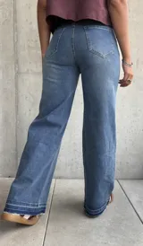 Jean de mujer color azul claro, de corte recto y tiro alto, con bolsillos delanteros decorativos con solapa y botón.