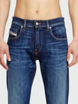 Jeans de hombre Diesel modelo D-Strukt, corte slim, en denim azul oscuro con efecto desgastado y lavado que se aclara hacia las rodillas y los muslos.