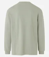 Remera verde claro de corte relajado, cuello redondo y manga larga. Confeccionada en tejido de media malla texturizada a rayas.