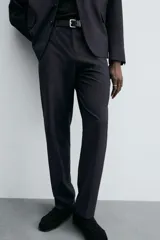 Pantalón de vestir negro de corte relaxed fit confeccionado en tejido con lana. Cuenta con bolsillos frontales y traseros de doble vivo con botón. Cierre frontal con cremallera y botón.