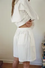 Short de algodón blanco con finas rayas verticales grises, tiro alto y cintura elástica.