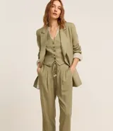 Pantalón fluido color verde oliva confeccionado en viscolino, con cintura elástica, lazo, pliegues y bolsillos.