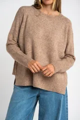 Sweater color marrón claro de tejido de punto, con cuello redondo y mangas largas.