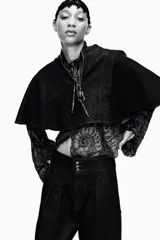 Pantalón bombacho de denim azul oscuro, tiro alto, con bolsillos delanteros y puños con botón en los tobillos. Cierre frontal con cremallera y botones metálicos.