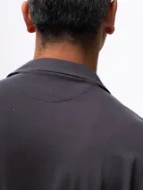 Camisa de manga corta color azul marino, confeccionada en tejido piqué de algodón. Presenta cuello cubano y cierre frontal de botones. Incluye un bolsillo de parche en el pecho izquierdo.