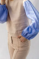 Blusa de lino color beige con mangas largas abullonadas en color azul.
