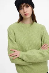 Buzo de punto color verde lima, con puños y cintura elastizada, y cuello redondo.