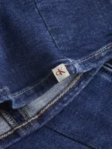 Vestido corto de denim azul, corte ajustado, sin mangas, con cierre metálico en la espalda y costura central en el frente.