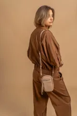 Bandolera compacta de símil cuero color rojo, con correa regulable y desmontable. Posee apertura superior, bolsillo frontal con cierre y bolsillo trasero abierto.