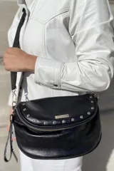 Bandolera de cuero celeste con correa de cinta regulable, forro de algodón, cierre central y bolsillo trasero con cierre.