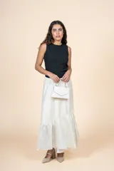 Falda larga color crudo, de silueta amplia con volado en el ruedo y cintura elástica.