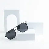 Lentes de sol estilo aviador con armazón metálico negro y lentes grises.
